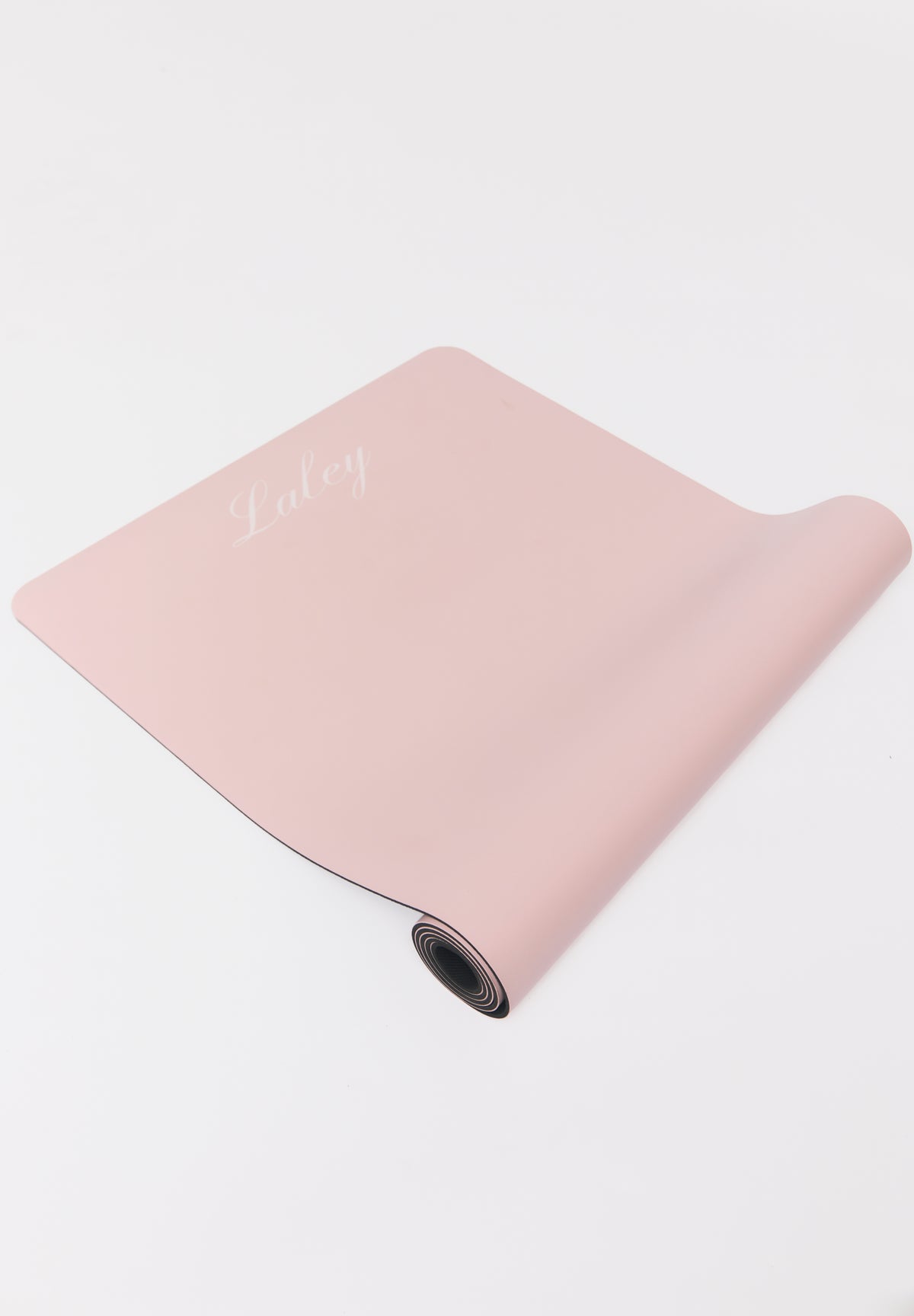 Nærbilde av logo, overflate og kant på Laley Grip treningsmatte rosa.