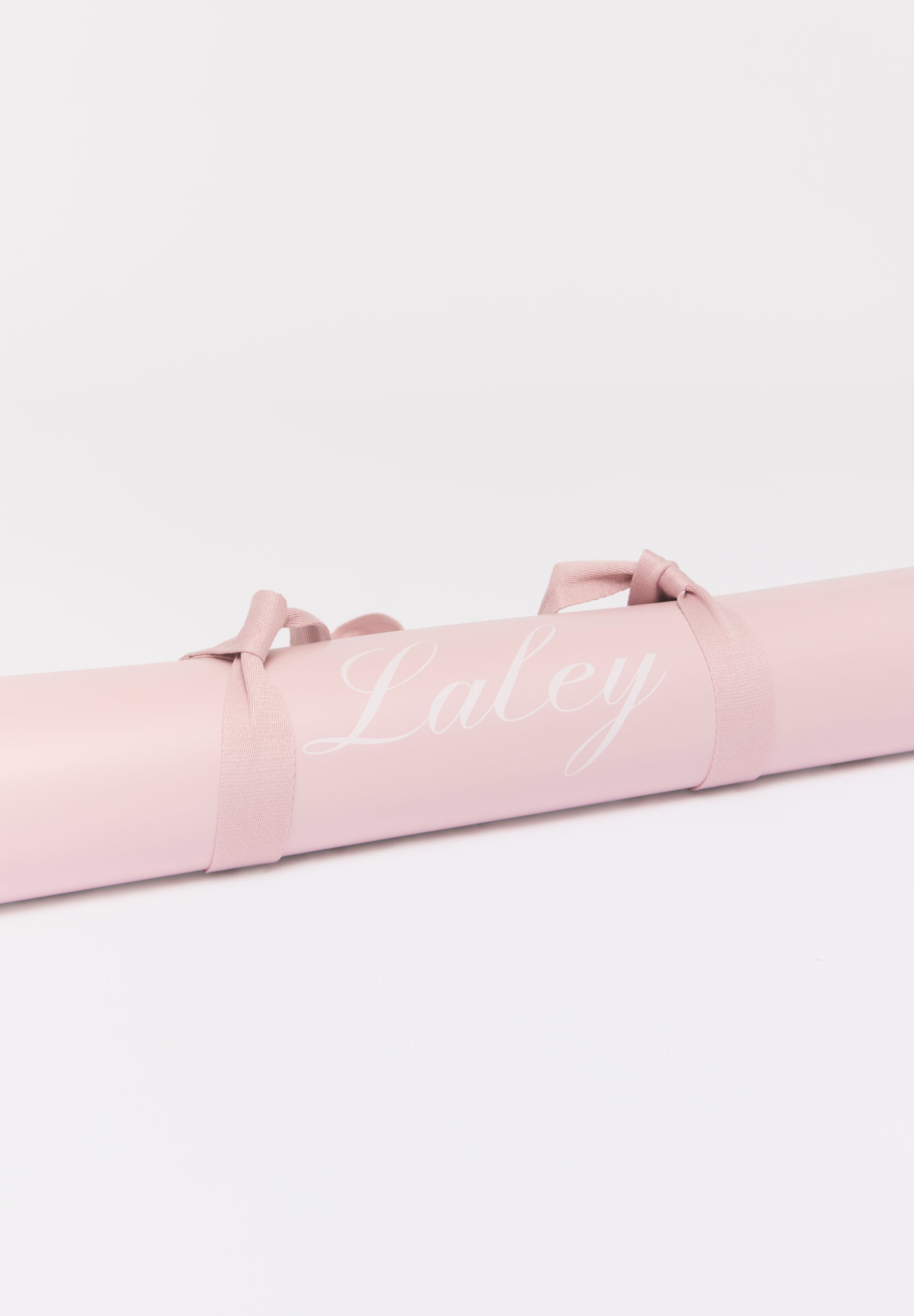 Packshot: Laley Grip treningsmatte rosa, sammenrullet med bærestropp.