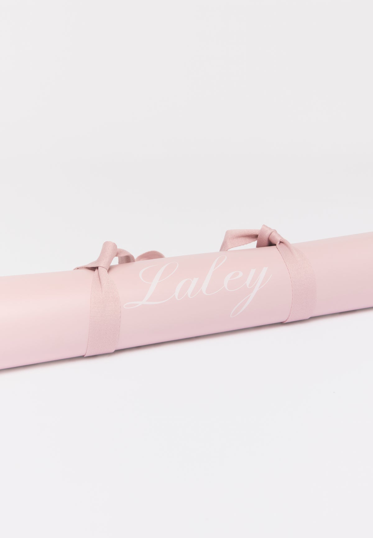 Packshot: Laley Grip treningsmatte rosa, sammenrullet med bærestropp.